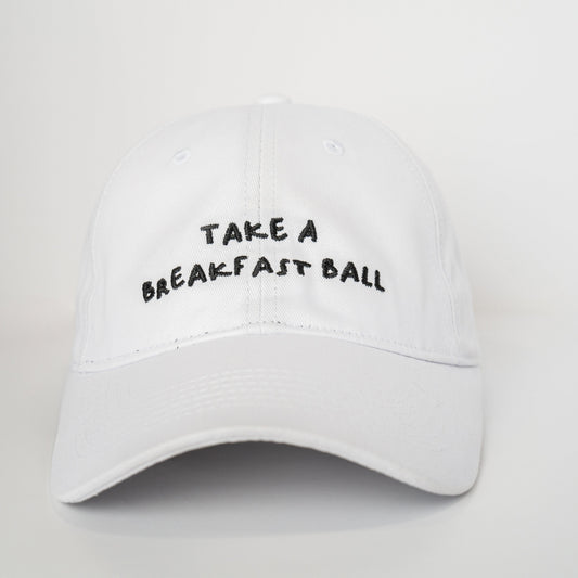 White cap with 'Take a Breakfast Ball' text on a light gray background