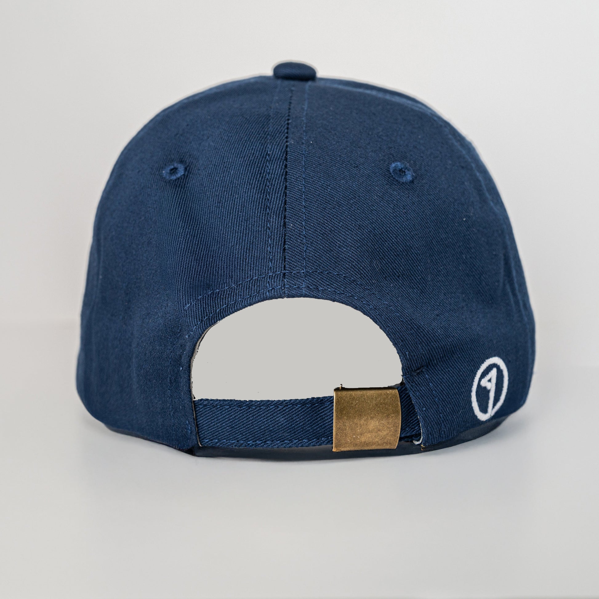 Navy blue cap with a gold patch on a light gray background