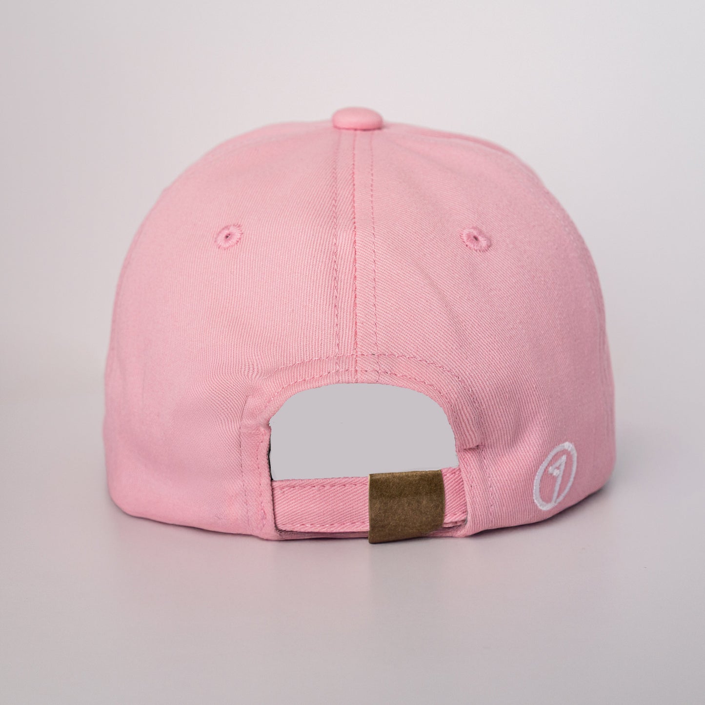 Pink cap with a brown patch on a light gray background