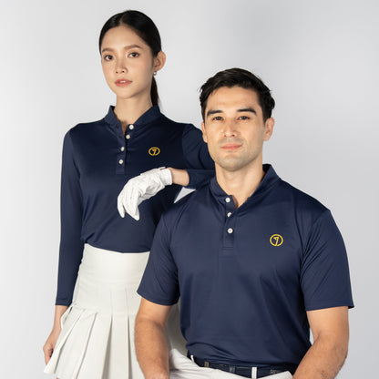 Two people in matching navy blue polo shirts and white pants, posing against a light gray background.