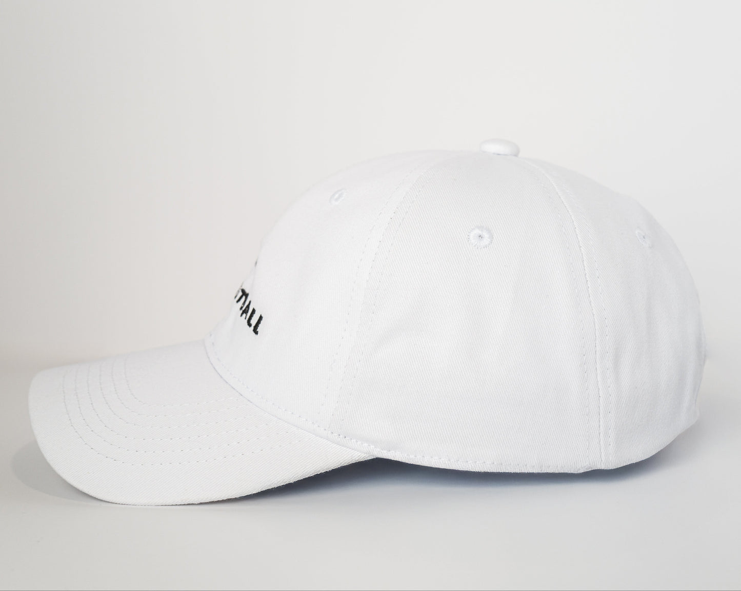White baseball cap with a small logo on a light gray background