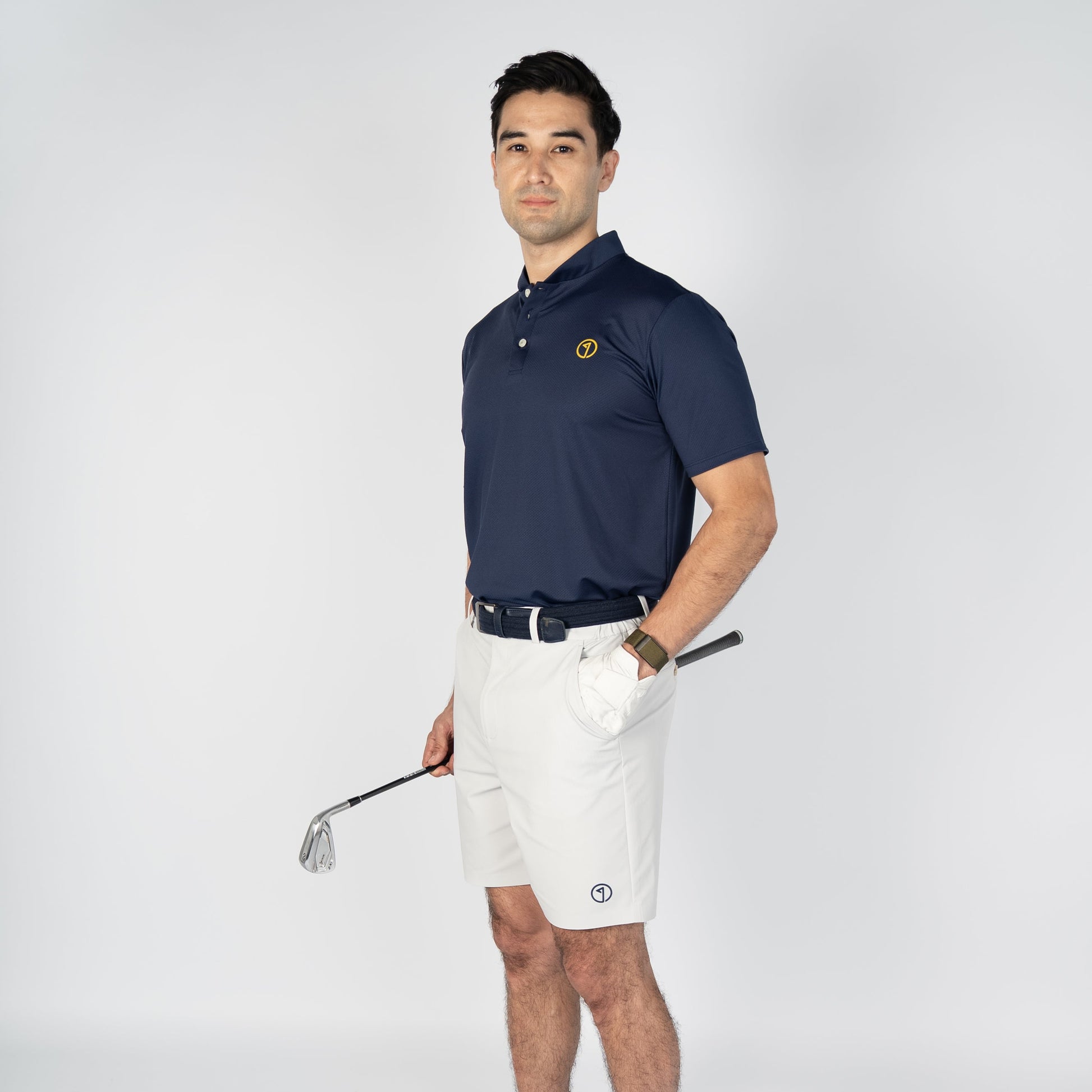 Man in golf attire holding a club on a white background