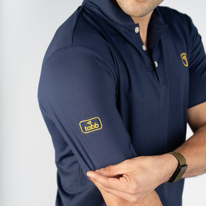 Man wearing a navy blue polo shirt with a logo on a white background