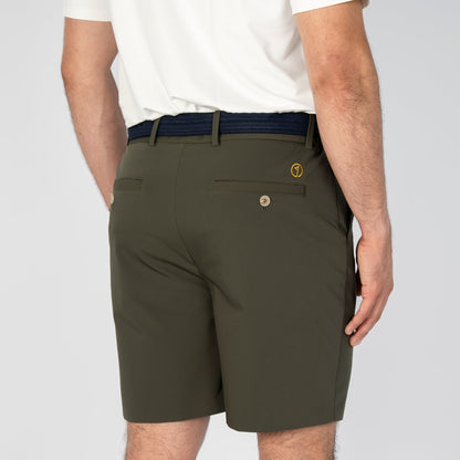 Person wearing olive green shorts and a white shirt on a plain background