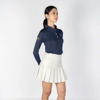 Woman wearing a navy blue polo shirt and white skirt on a white background